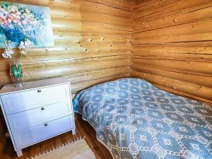 een slaapkamer met een bed en een houten wand bij Holiday Home Illankajo by Interhome in Suninsalmi +3 foto's