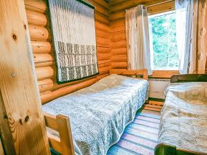 een slaapkamer met een bed in een blokhut bij Holiday Home Illankajo by Interhome in Suninsalmi