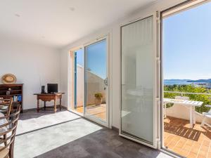 une pièce avec une porte coulissante en verre donnant sur un balcon dans l'établissement Apartment Les Bougainvillées by Interhome, au Lavandou