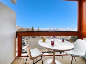 a table and chairs on a balcony with a view at Apartment Soyouz Vanguard-82 by Interhome in Le Corbier