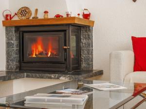 uma lareira numa sala de estar com um sofá e uma mesa em Apartment Les Cimes by Interhome em Les Crosets