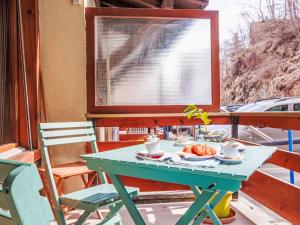 a green table with a plate of food on a porch at Studio Quille du Diable 4 by Interhome in Nendaz