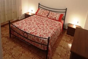 a bedroom with a bed with a red comforter at Stella Marina 296 in Torvaianica