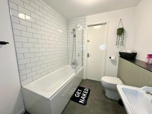a bathroom with a tub and a toilet and a sink at City Haven - 2 Bed in Sheffield - LuxeSuites in Midland +30 photos