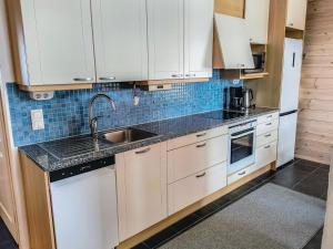 eine Küche mit weißen Schränken und einer Spüle in der Unterkunft Holiday Home Pikku-pölly by Interhome in Vuokatti