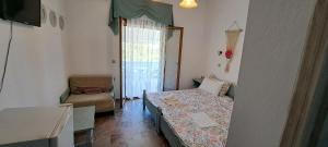 a small room with a bed and a chair at Roptro Rooms in Parga