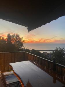 a balcony with a view of the ocean at sunset at Loya Butik Otel Bungalov in Rize
