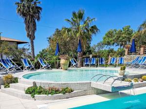 una piscina con sillas azules y palmeras en Apartment Heaven-2 by Interhome, en Santa María