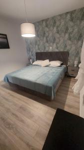 a bedroom with a bed with a blue comforter at Apartment Modrić Zadar II in Zadar