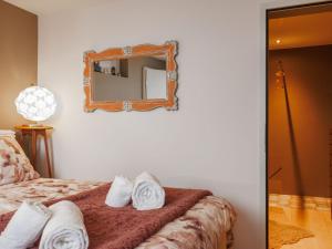 Un dormitorio con una cama con un espejo en la pared. en Apartment Lau'tentik by Interhome, en Monthey