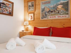 シャンペリーにあるApartment Neige et Soleil by Interhomeの赤と白の枕が備わるベッド2台(1室あたり)