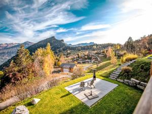 a view of a garden with two chairs on a lawn at Chalet La Luna by Interhome in Ovronnaz