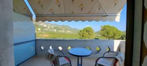 a table and chairs on a balcony with a view at Roptro Rooms in Parga