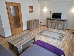 a living room with a wooden floor and a wooden door at Ferienhaus "Am Schlossbühel" für 9 Personen in Wernigerode