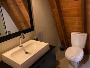 a bathroom with a white sink and a toilet at Cabana Amélia, em Gramado in Gramado
