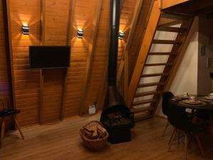a wood stove in a room with a tv at Cabana Amélia, em Gramado in Gramado