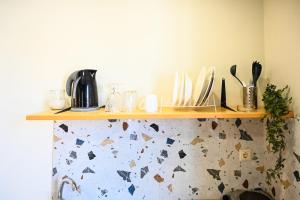 a shelf on a wall with dishes on it at Cozy Studio #7 in Malia