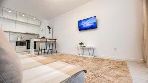 una cocina con paredes blancas y una pintura en la pared en ЖК Auezov City- в центре города, en Almaty