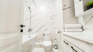 Un baño blanco con inodoro y lavabo. en ЖК Auezov City- в центре города, en Almaty