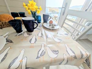 a table with a table cloth with birds on it at Pod Beag beside the sea Isle of Eriskay in Eriskay +27 photos