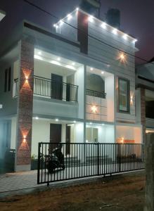 Una casa blanca con luces por la noche. en Palm Paradise Beach Resort Varkala, en Varkala