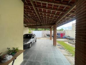 a car parked under a pergola in a garage at Casa espaçosa e conectada com a natureza in Cananéia