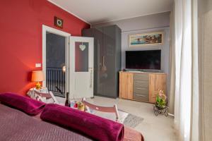 a red bedroom with a bed and a television at Histria Residence in Umag