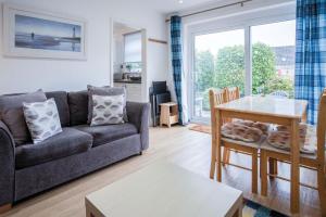 a living room with a couch and a table at Bayview 58 - 2 Bedroom Chalet - Bayview Oxwich in Oxwich
