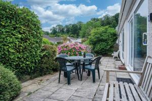 a patio with a table and chairs and flowers at Bayview 58 - 2 Bedroom Chalet - Bayview Oxwich in Oxwich