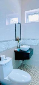 a white bathroom with a toilet and a sink at Bao Anh An Bang beach villa in Tân Thành (1)