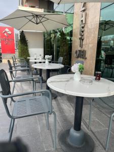 una fila de mesas con sillas y una sombrilla en Nüzhet Hotel, en Kayseri