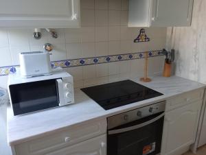 a kitchen with a microwave and a stove top oven at Albufeira INN - Mulatinho V2 in Olhos de Água