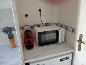 a microwave sitting on top of a counter in a kitchen at Albufeira INN - Mulatinho V2 in Olhos de Água +32 photos