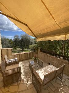 a patio with chairs and a table and a large umbrella at Bastide de Peyloubet in Grasse