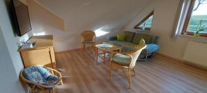 a living room with a couch and chairs and a table at Ferienwohnungen Lahmenhof in Poppenhausen