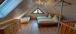 a attic room with two beds and a window at Ferienwohnungen Lahmenhof in Poppenhausen