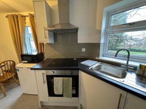 a kitchen with a sink and a stove and a window at Fun 7 holidays entire flat in Huntingdon