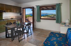 a kitchen and dining room with a table and chairs at Residence Il Mirto in Palau