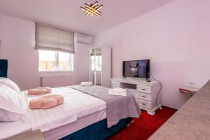 a bedroom with a bed and a dresser and a television at Boutique Boema in Târgovişte