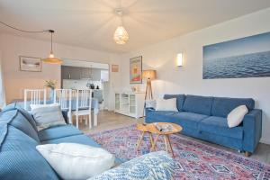 ein Wohnzimmer mit einem blauen Sofa und einem Tisch in der Unterkunft Osterhuus in Norden