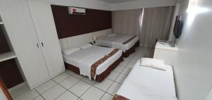 a hotel room with two beds and a television at Le Jardin Suites Luxo - Central de Reservas in Caldas Novas +73 photos