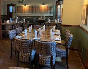 a dining room with a wooden table and chairs at Gordon Arms Hotel in West Linton