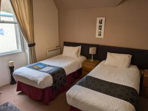 a hotel room with two beds and a window at Gordon Arms Hotel in West Linton +18 photos