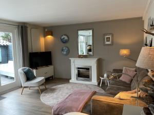 a living room with a couch and a tv at Appelbloesem in Bergen