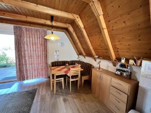 a kitchen and dining room with a wooden ceiling at Rehblick RE11 in Sögel