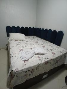 a bedroom with a bed with a blue headboard at aconchego pe na areia in Ilhéus
