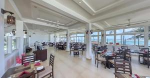 a dining room with tables and chairs and the ocean at Manara Beach Resort in Bentota