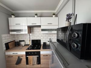 a kitchen with a stove and a washer and dryer at Monetto Apartman in Csongrád