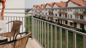 a balcony with chairs and a view of some buildings at Baltic Korona, Sun & Snow in Darłowo