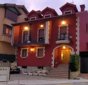 a red house with a yellow door at Hosteria Los Laureles in Noja